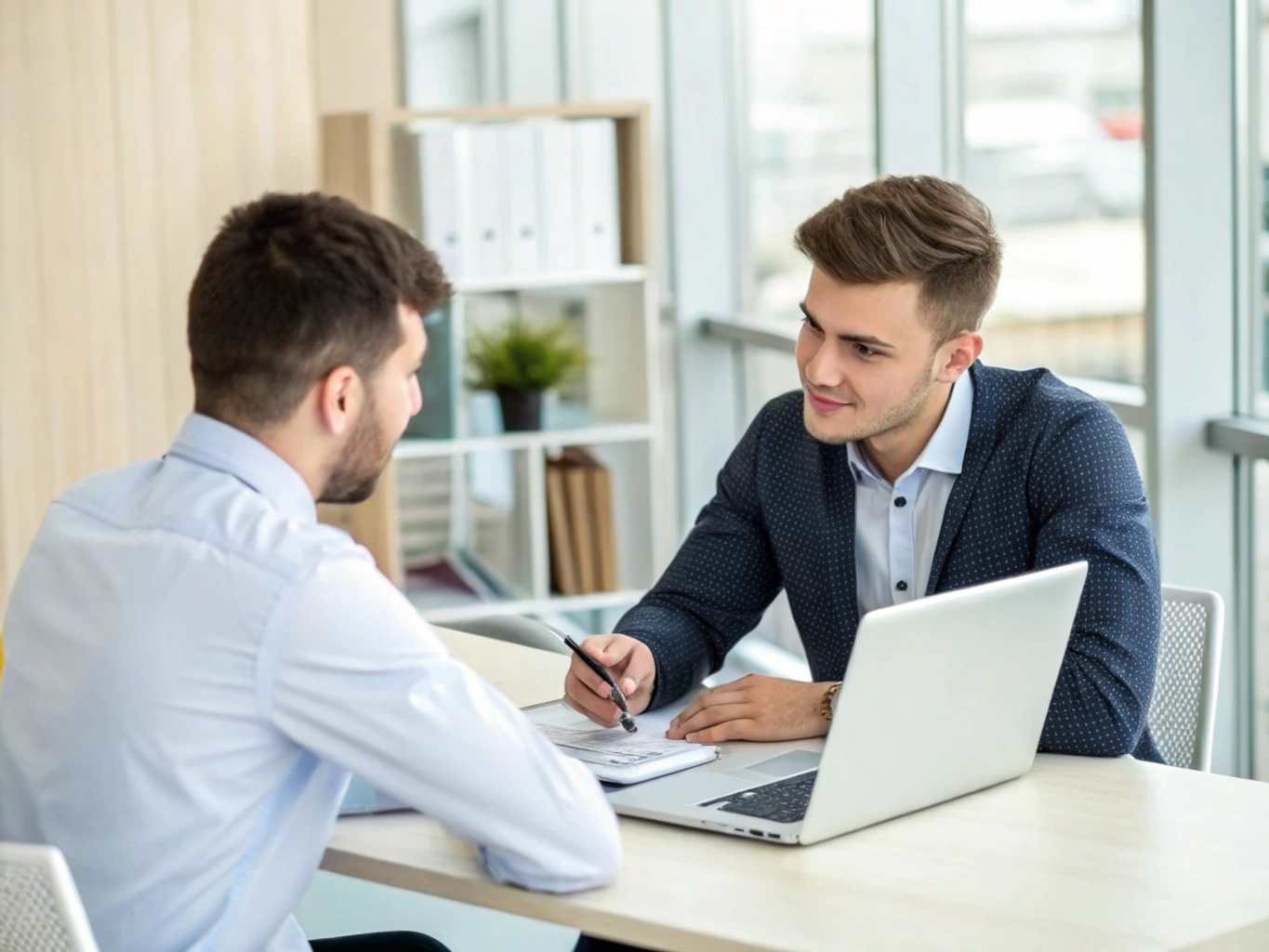 Two recruitment consultants closely reviewing resume portfolios and project briefs in a modern office